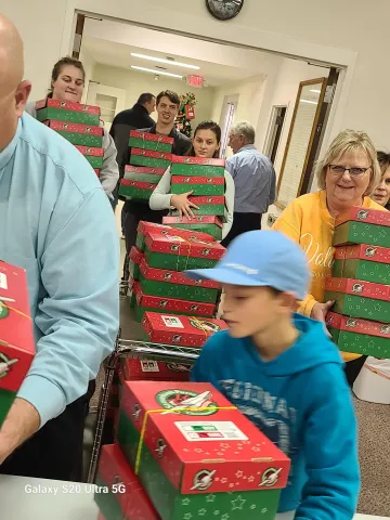 Short-term volunteers carry in shoeboxes for counting and cartonizing