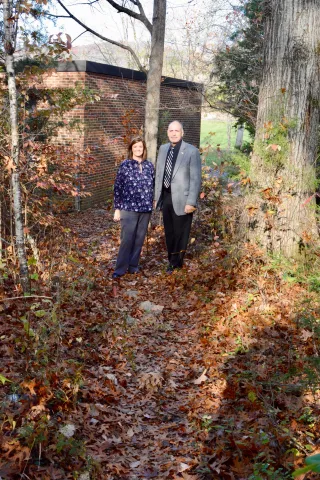 Luttrell Elementary School principal Sonja Saylor and Union County Mayor Mike Williams stand on the path that students use to get from Lafollette Housing Authority apartments to the school. The path will be paved and lighted with a new grant from Safe Routes to School.