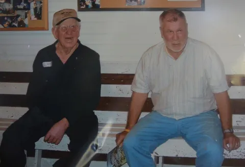 The late Bit Rouse (left) sits with Dean Stiner in this snapshot on the history wall in Rush Strong School. Rouse, known as the one-armed fiddle player, was the driving force behind the jam sessions until his passing.