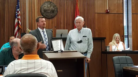 Man giving a plaque to a veteran