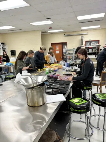 Culinary Arts 1 class making Thanksgiving Dinner for staff, students, and parents. The room is buzzing with busy, excited students as they peel, slice, cut, de-bone, mix, and prepare.