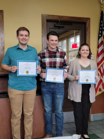 Three students holding certificates