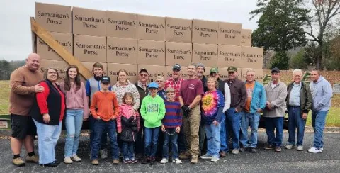 Short-term volunteers gather around a loaded trailer carrying 2595 gospel opportunities from Union County donors.