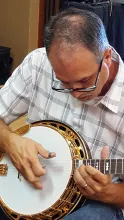 Stuart Wyrick is tuning and picking a banjo