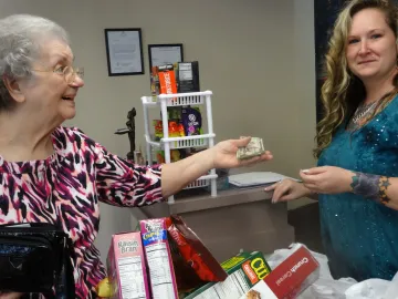 Wanda Cox Byerley receives change for her purchases from Serena.