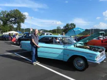 Man standing next to a vintage car