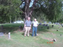 Jay Ricketts and John Cabage standing near the burial site of Alfred Gallatin Rickets in Cabbage Cemetery