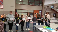 A group of children and their teacher at a meeting